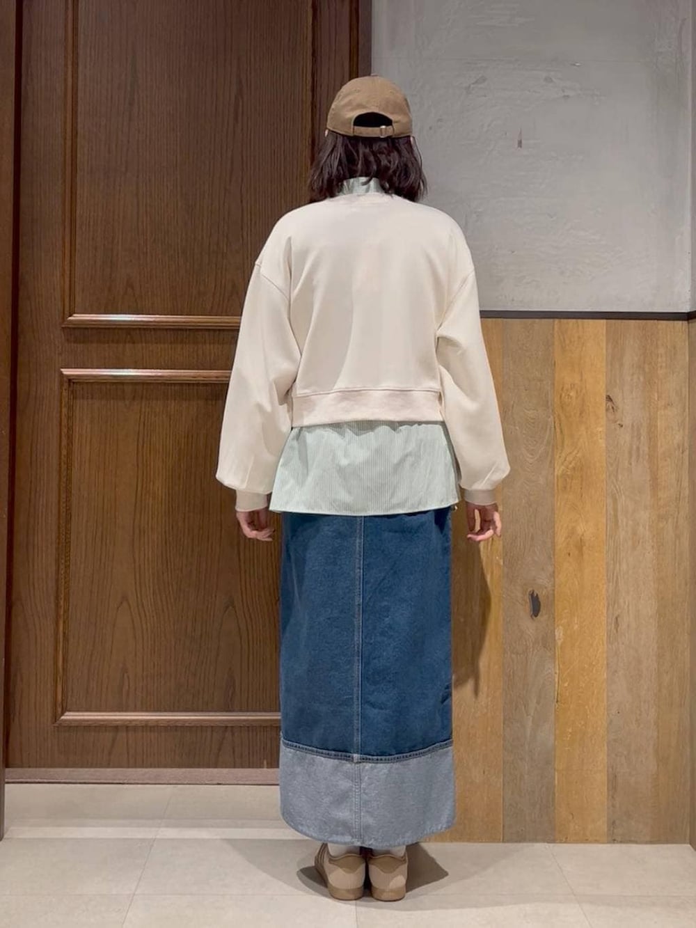 ベージュ系のスニーカー、ホワイト系のスウェット、ブルー系のデニムスカートを着用したレディースの春コーディネートの4枚目の写真