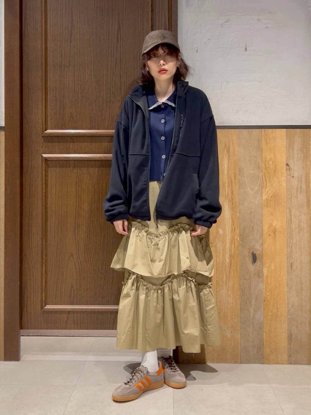 ブルー系のニット/セーター、ベージュ系のスカート、ブルー系のブルゾンを着用したレディースの冬コーディネートの2枚目の写真