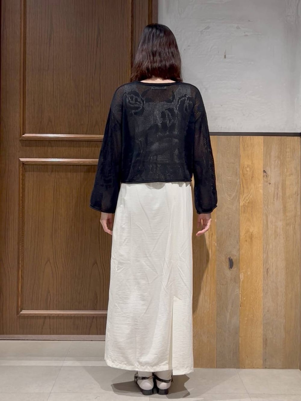 ブラック系のパンプス、ホワイト系のスカート、ホワイト系のタンクトップを着用したレディースの春コーディネートの4枚目の写真