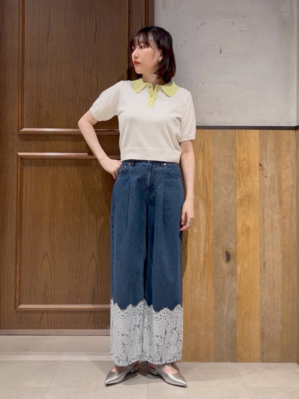 シルバー系のパンプス、ブルー系のデニムパンツ、ホワイト系のポロシャツを着用したレディースの夏コーディネートの2枚目の写真