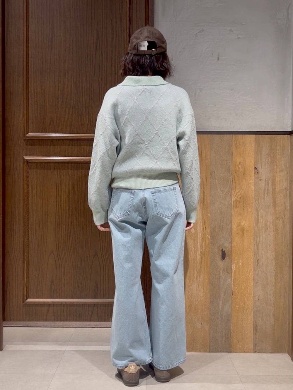 ベージュ系のスニーカー、ブルー系のデニムパンツ、グリーン系のTシャツ/カットソーを着用したレディースの冬コーディネートの4枚目の写真