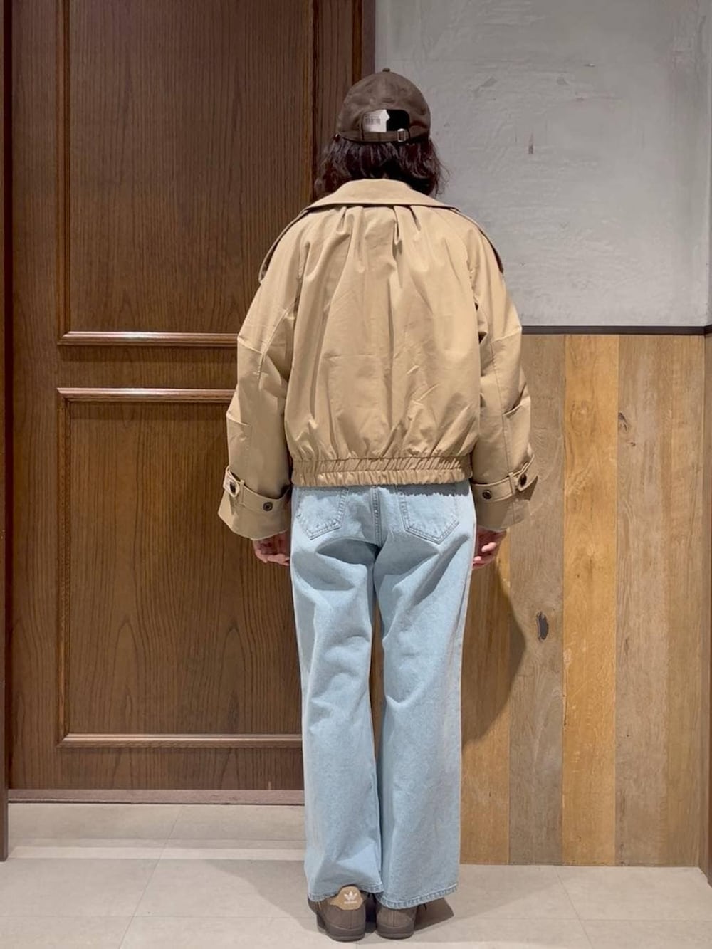 ベージュ系のスニーカー、ブルー系のデニムパンツ、グリーン系のTシャツ/カットソーを着用したレディースの冬コーディネートの2枚目の写真