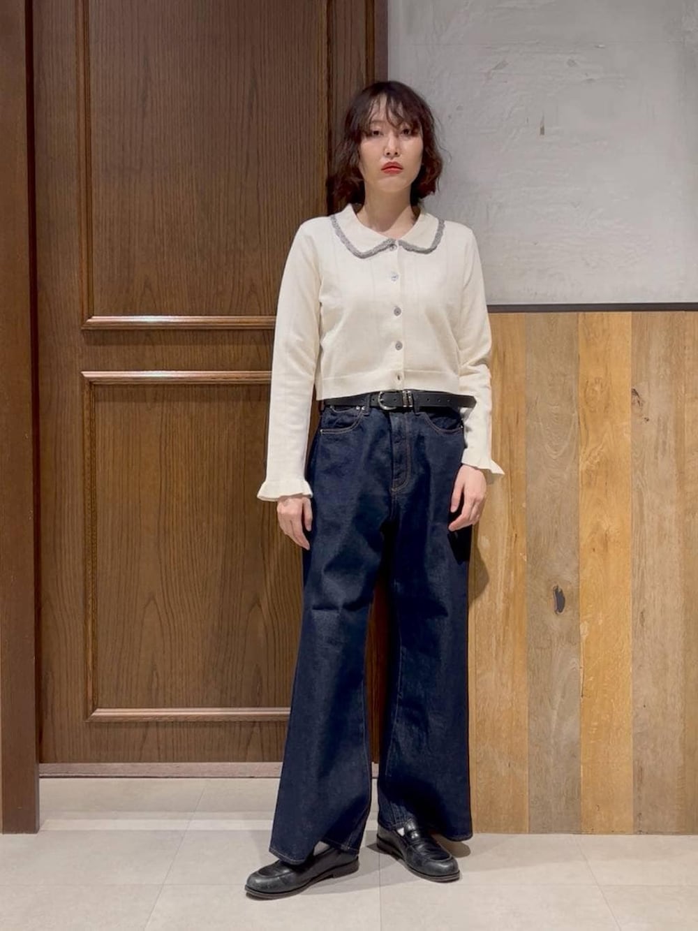 ブルー系のデニムパンツ、ホワイト系のカーディガン/ボレロ、ブラック系のテーラードジャケットを着用したレディースの冬コーディネートの3枚目の写真