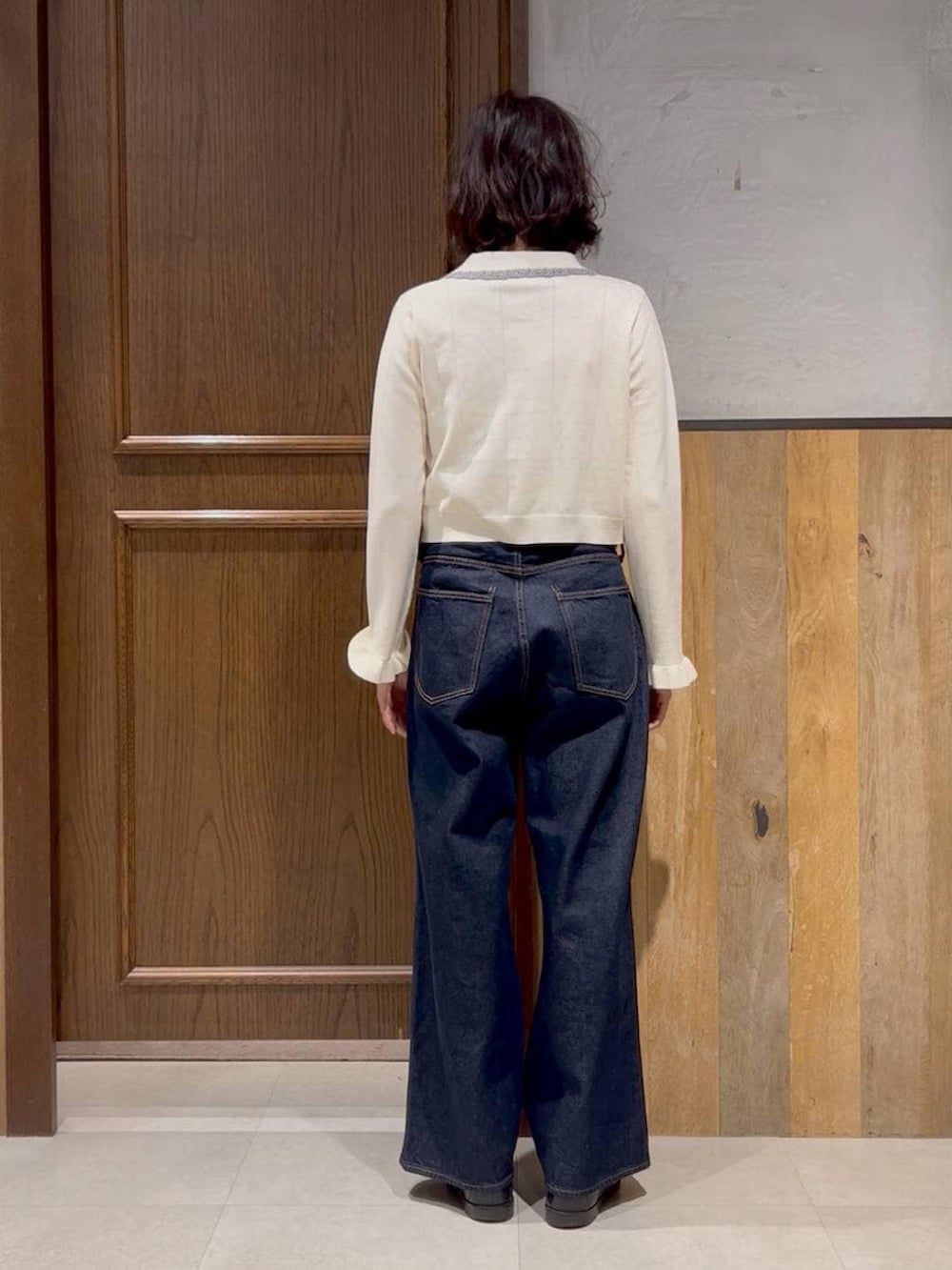 ブルー系のデニムパンツ、ホワイト系のカーディガン/ボレロ、ブラック系のテーラードジャケットを着用したレディースの冬コーディネートの4枚目の写真