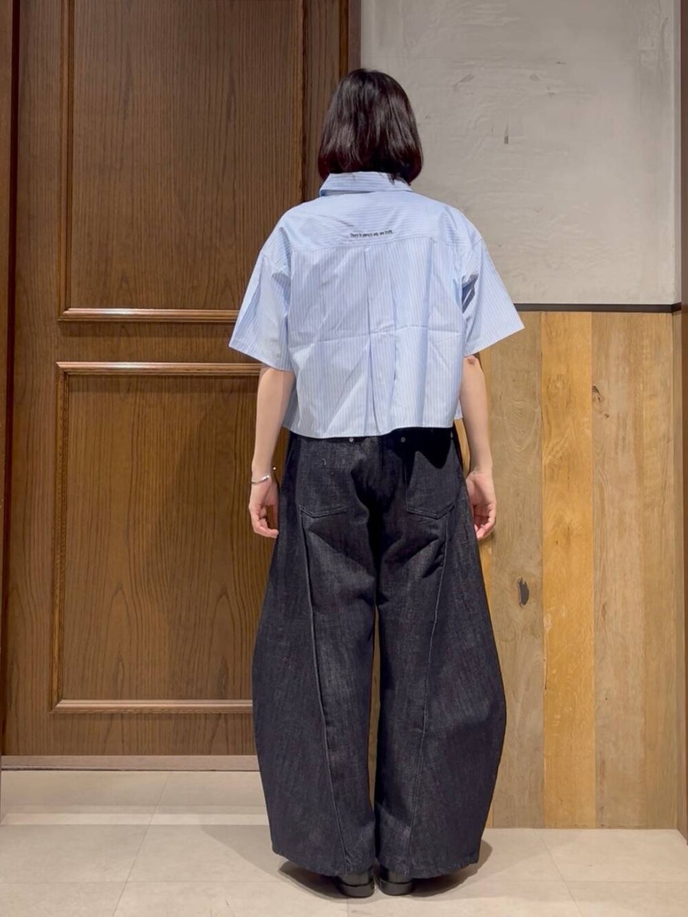 ブルー系のデニムパンツ、ブラック系のキーホルダーを着用したレディースの春コーディネートの2枚目の写真