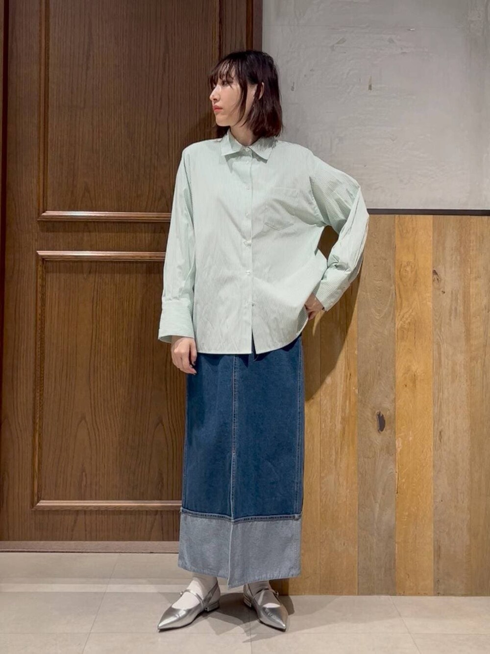 ベージュ系のスニーカー、ホワイト系のスウェット、ブルー系のデニムスカートを着用したレディースの春コーディネートの5枚目の写真