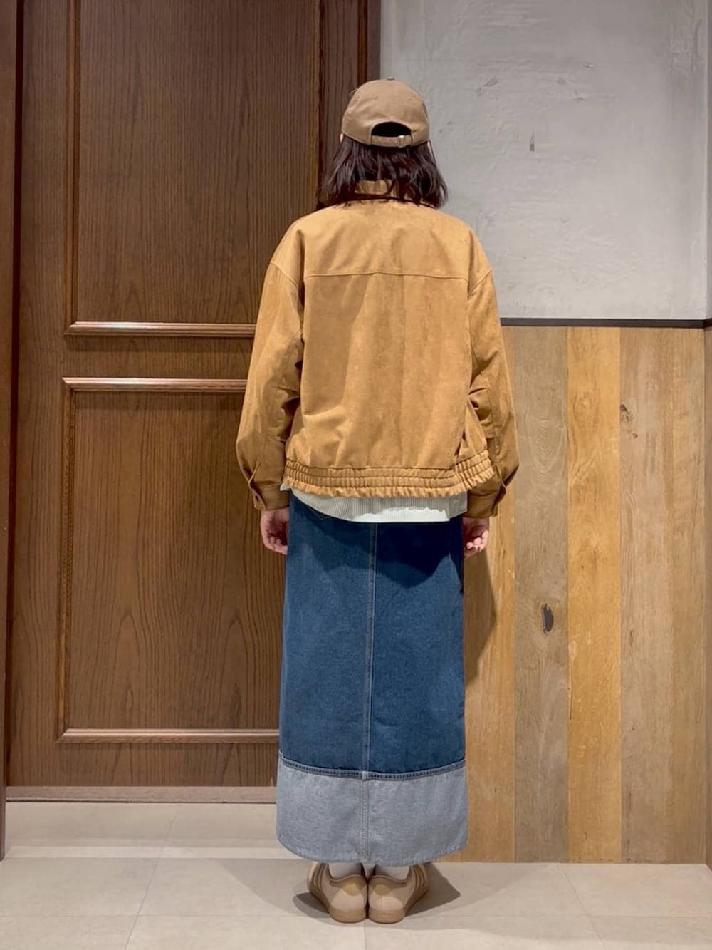 ベージュ系のスニーカー、ホワイト系のスウェット、ブルー系のデニムスカートを着用したレディースの春コーディネートの2枚目の写真