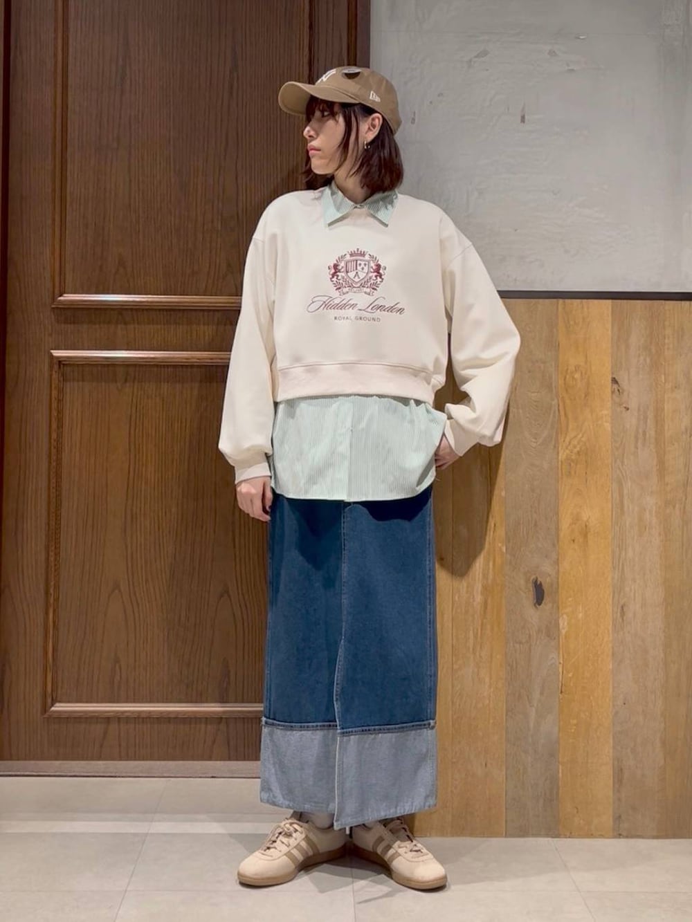 ベージュ系のスニーカー、ホワイト系のスウェット、ブルー系のデニムスカートを着用したレディースの春コーディネートの3枚目の写真