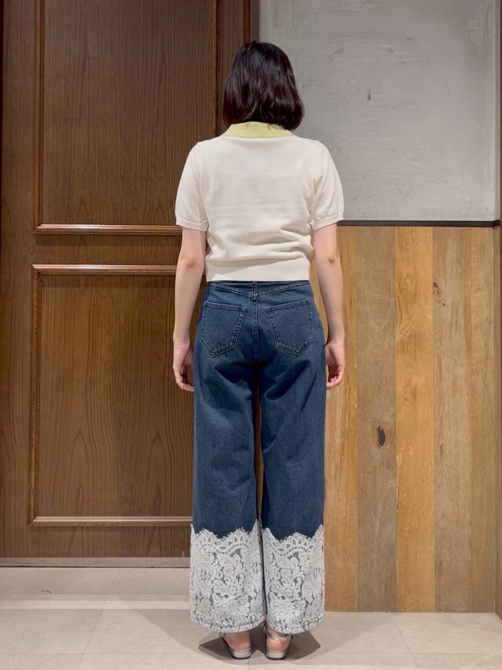 シルバー系のパンプス、ブルー系のデニムパンツ、ホワイト系のポロシャツを着用したレディースの夏コーディネートの3枚目の写真