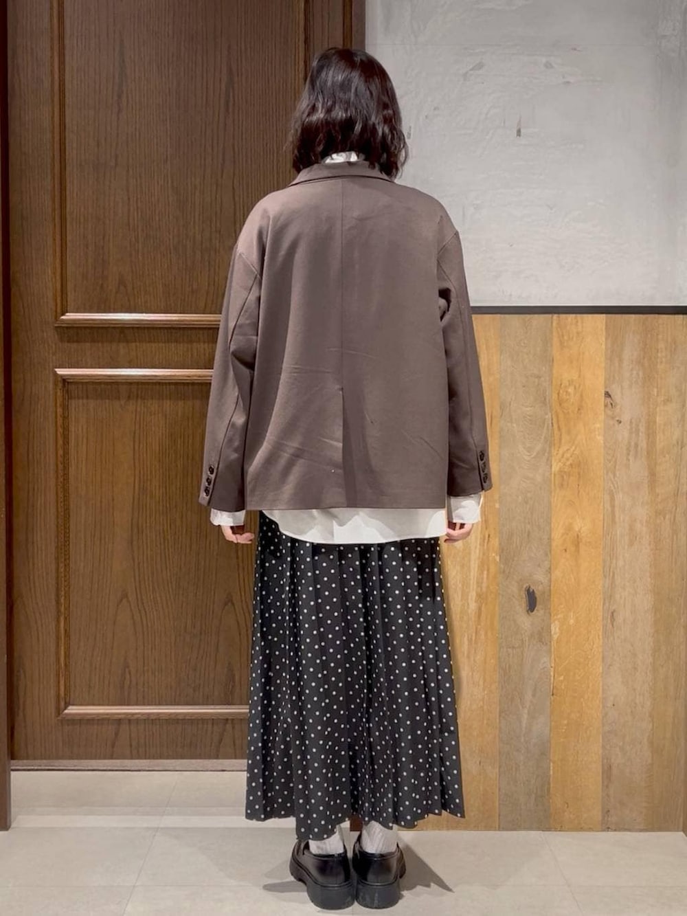 ブラウン系のテーラードジャケット、ブラック系のドレスシューズ、ホワイト系のシャツ/ブラウスを着用したレディースの冬コーディネートの2枚目の写真