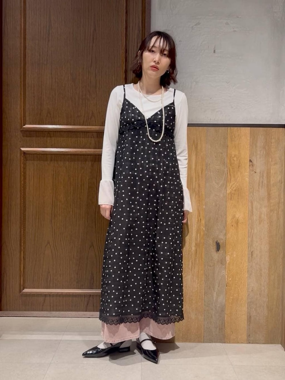 ブラック系のパンプス、ピンク系のデニムパンツ、パープル系のパーカーを着用したレディースの冬コーディネートの2枚目の写真