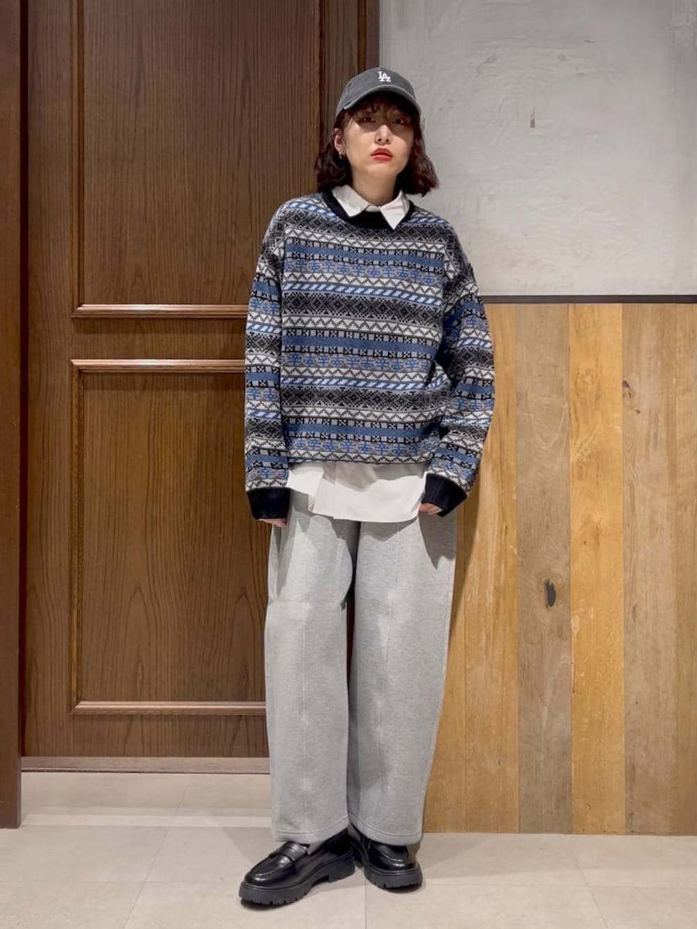 ホワイト系のシャツ/ブラウス、グレー系のスウェットパンツ、ブルー系のニット/セーターを着用したレディースの秋コーディネートの2枚目の写真