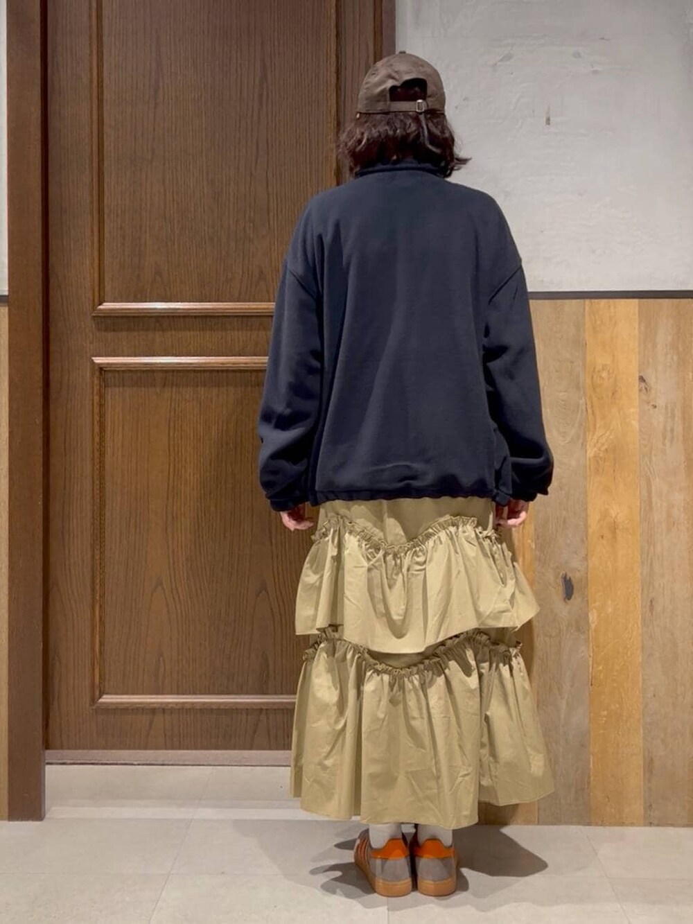 ブルー系のニット/セーター、ベージュ系のスカート、ブルー系のブルゾンを着用したレディースの冬コーディネートの3枚目の写真