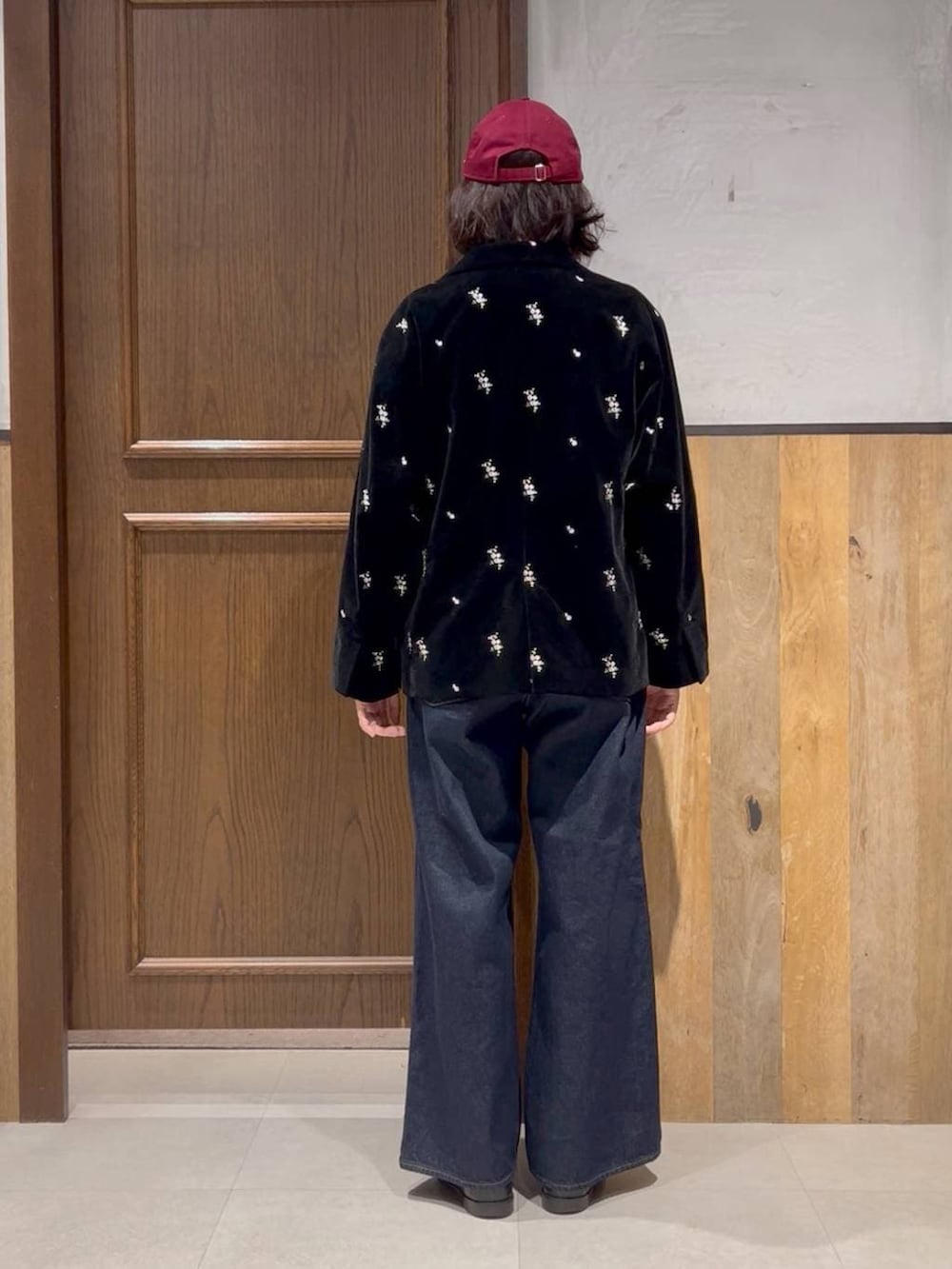 ブルー系のデニムパンツ、ホワイト系のカーディガン/ボレロ、ブラック系のテーラードジャケットを着用したレディースの冬コーディネートの2枚目の写真