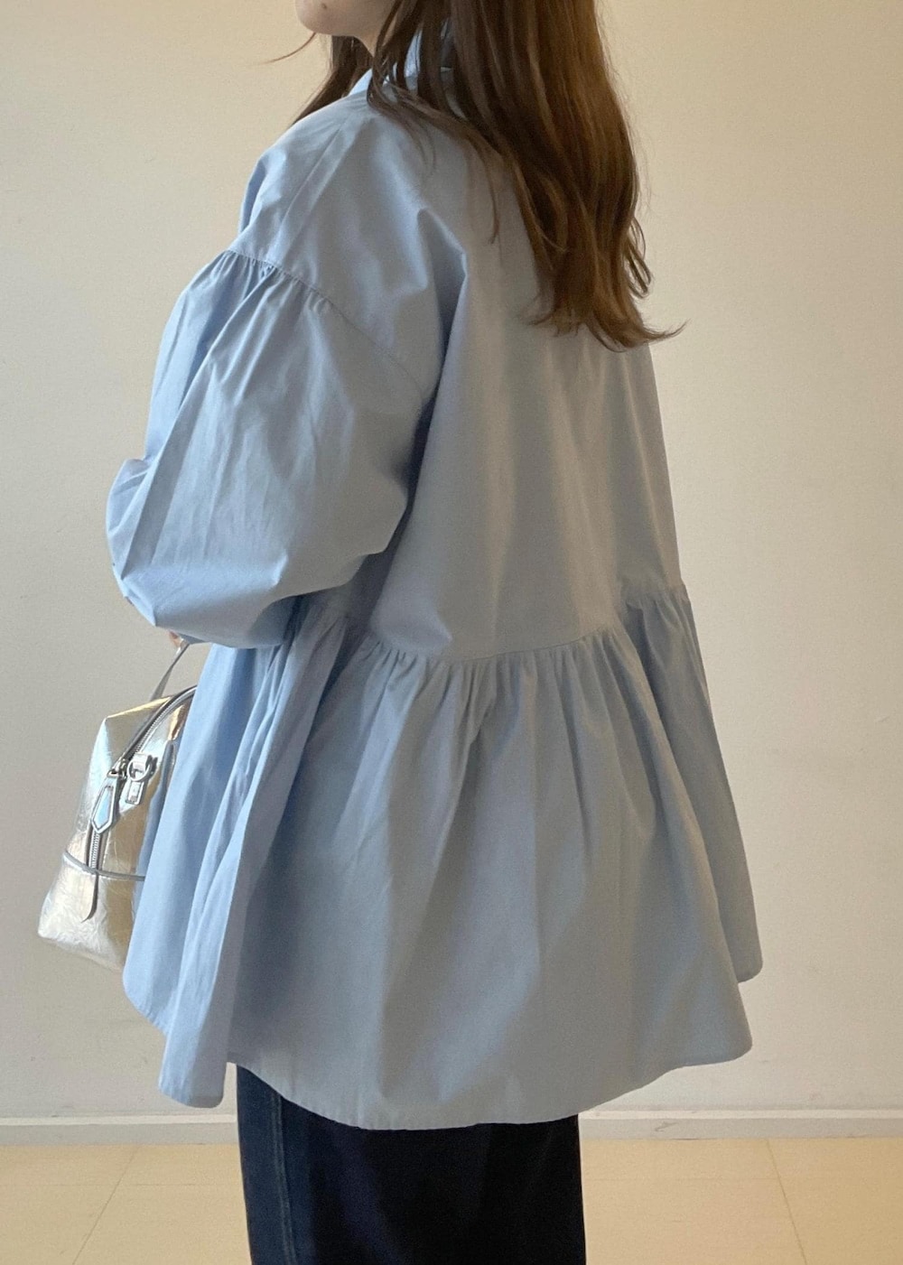 シルバー系のパンプス、ブルー系のデニムパンツ、シルバー系のボストンバッグを着用したレディースの秋コーディネートの8枚目の写真