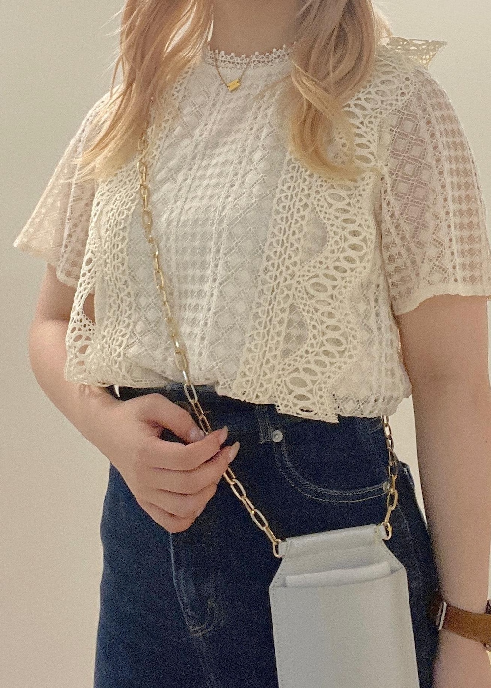 ブルー系のデニムパンツ、シルバー系のサンダル、シルバー系のショルダーバッグを着用したレディースの夏コーディネートの9枚目の写真