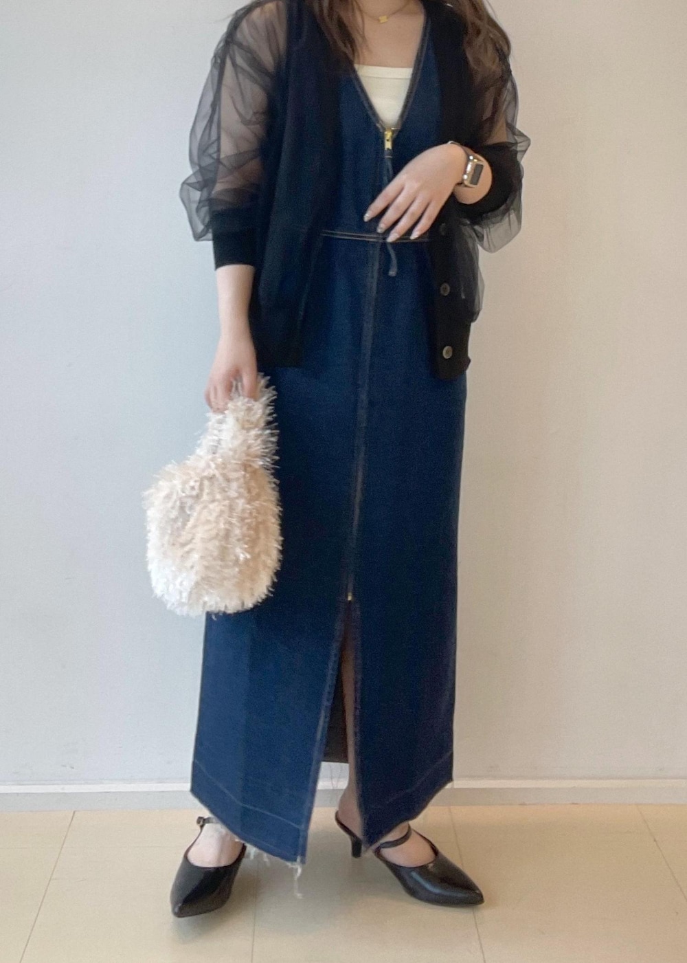 ホワイト系のタンクトップ、ベージュ系のハンドバッグ、ブラック系のパンプスを着用したレディースの秋コーディネートの5枚目の写真