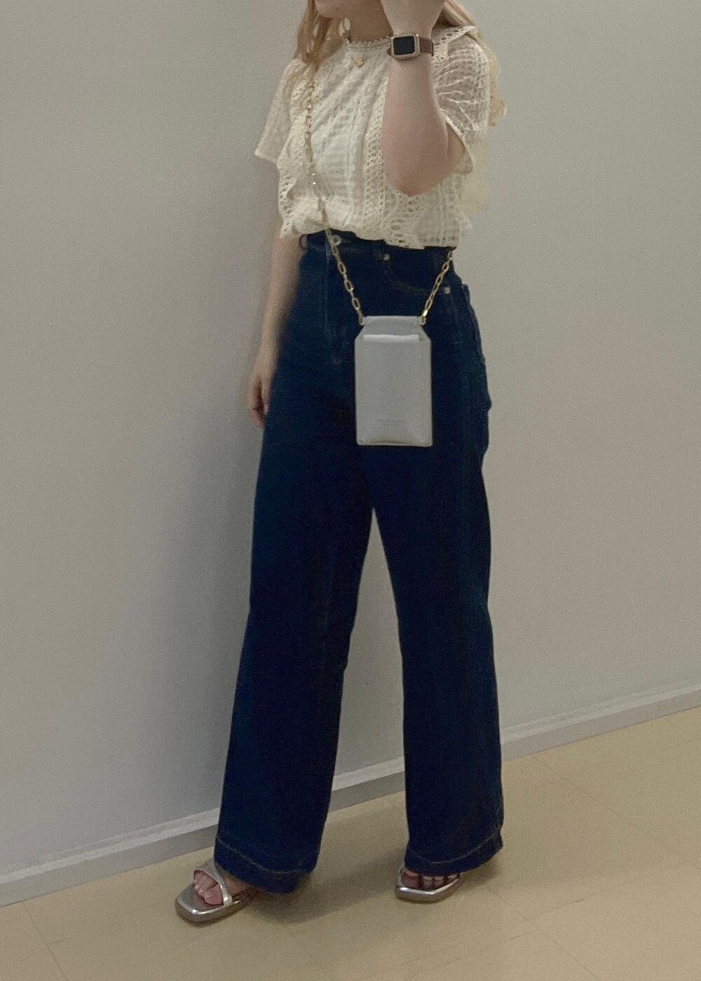 ブルー系のデニムパンツ、シルバー系のサンダル、シルバー系のショルダーバッグを着用したレディースの夏コーディネートの3枚目の写真