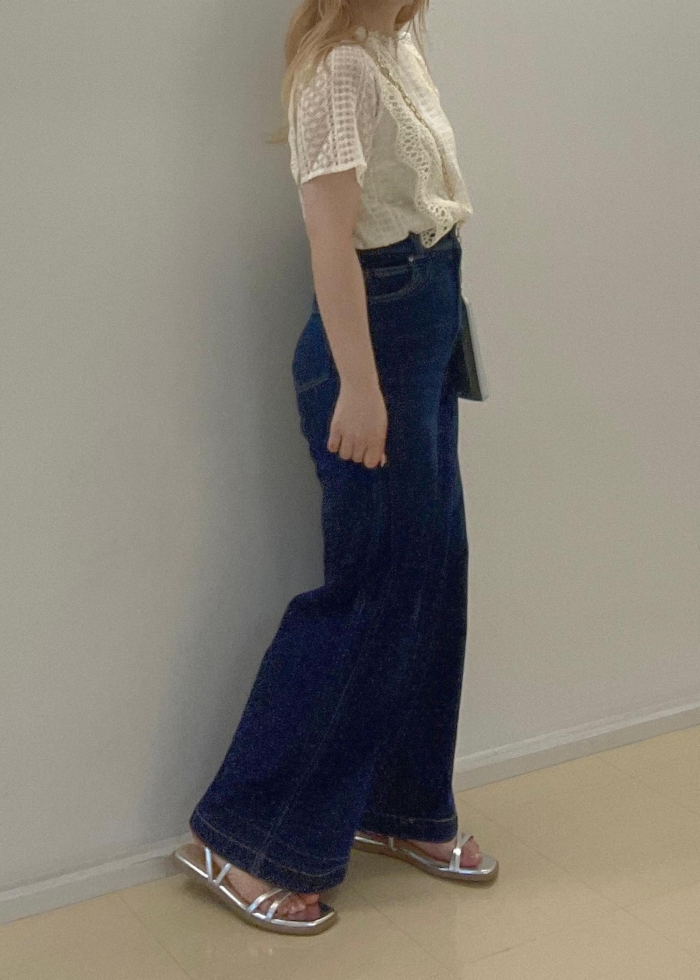 ブルー系のデニムパンツ、シルバー系のサンダル、シルバー系のショルダーバッグを着用したレディースの夏コーディネートの6枚目の写真