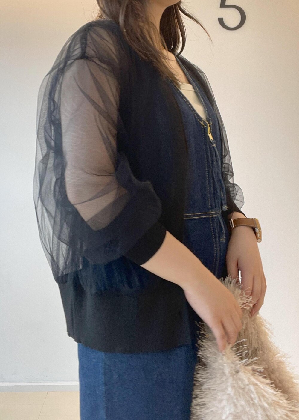 ホワイト系のタンクトップ、ベージュ系のハンドバッグ、ブラック系のパンプスを着用したレディースの秋コーディネートの9枚目の写真