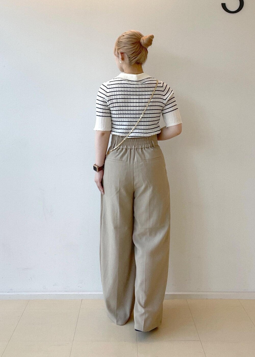 ブラック系のサンダル、ベージュ系のその他パンツ、ホワイト系のニット/セーターを着用したレディースの夏コーディネートの2枚目の写真