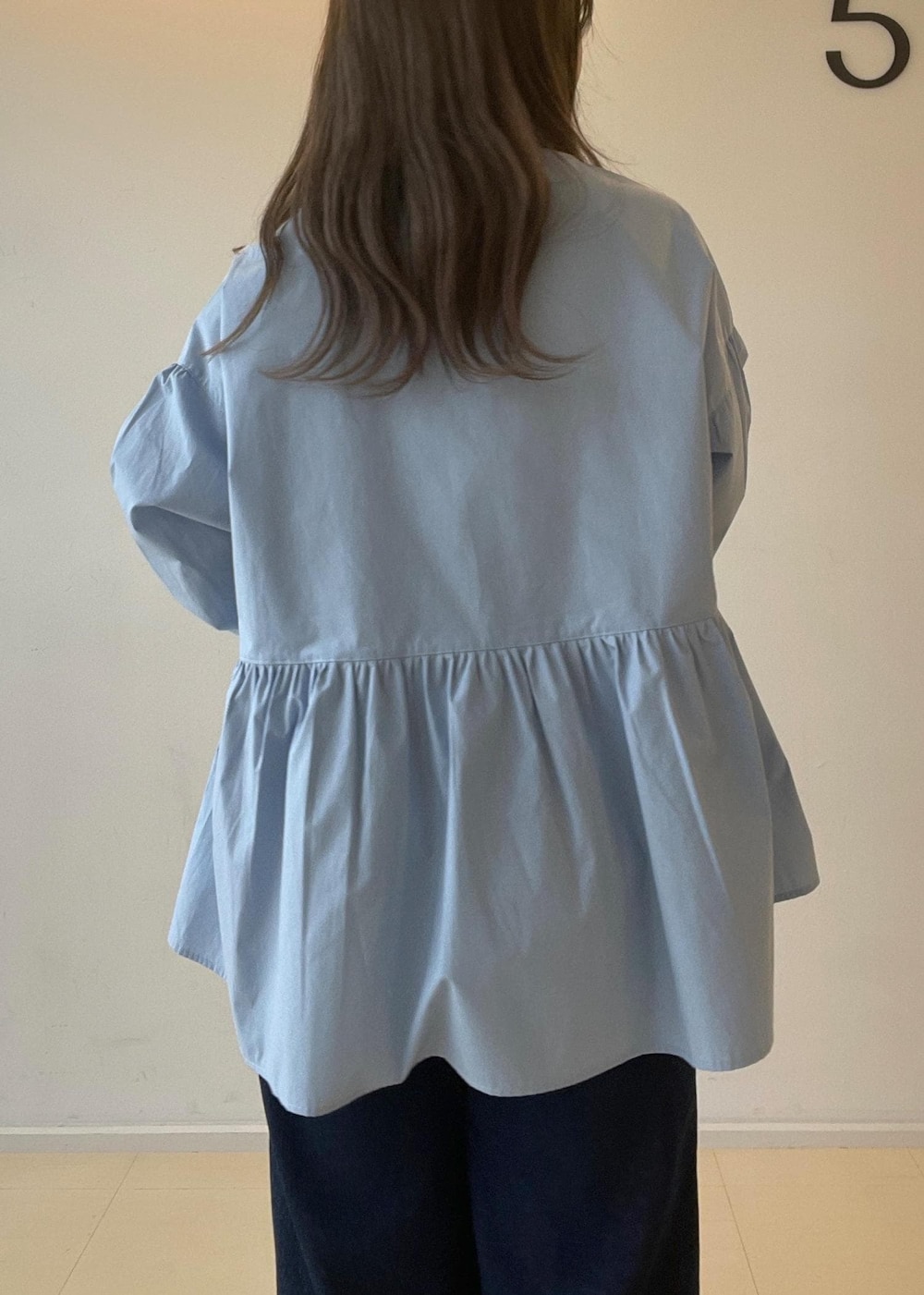 シルバー系のパンプス、ブルー系のデニムパンツ、シルバー系のボストンバッグを着用したレディースの秋コーディネートの9枚目の写真