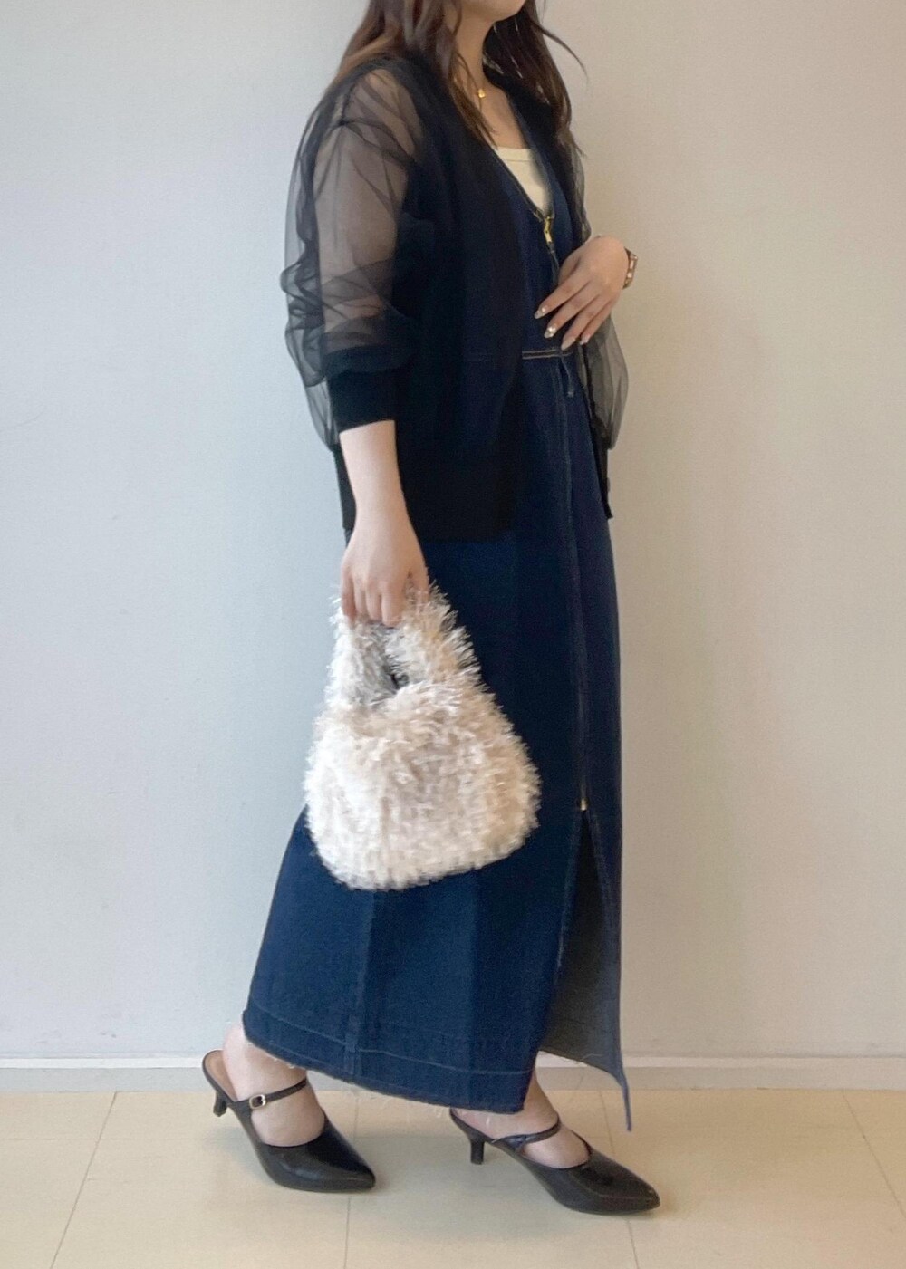 ホワイト系のタンクトップ、ベージュ系のハンドバッグ、ブラック系のパンプスを着用したレディースの秋コーディネートの6枚目の写真