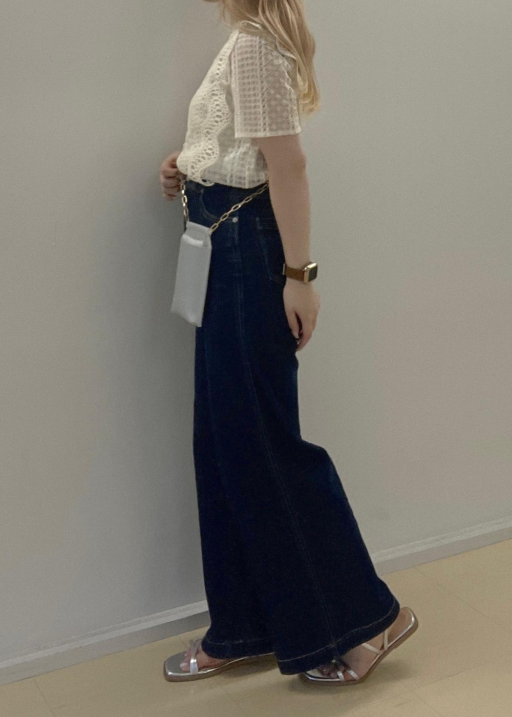 ブルー系のデニムパンツ、シルバー系のサンダル、シルバー系のショルダーバッグを着用したレディースの夏コーディネートの5枚目の写真