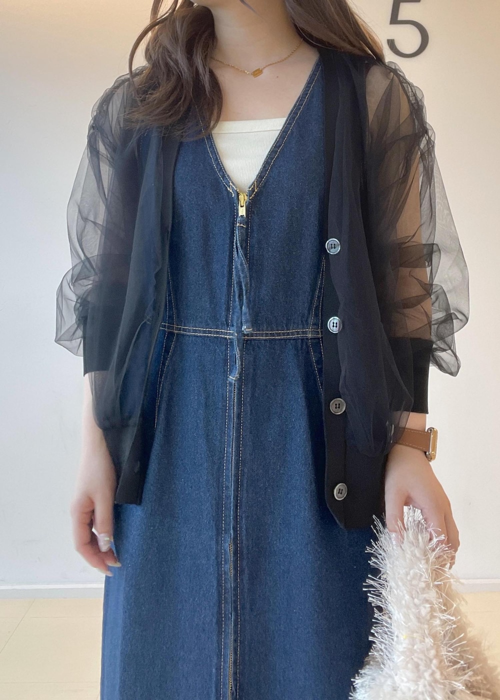 ホワイト系のタンクトップ、ベージュ系のハンドバッグ、ブラック系のパンプスを着用したレディースの秋コーディネートの8枚目の写真