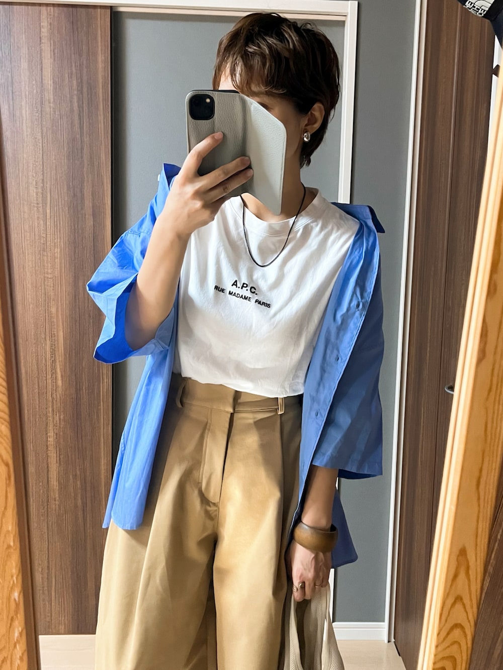 ホワイト系のTシャツ/カットソー、ブルー系のシャツ/ブラウス、ベージュ系のチノパンツを着用したレディースの秋コーディネートの2枚目の写真