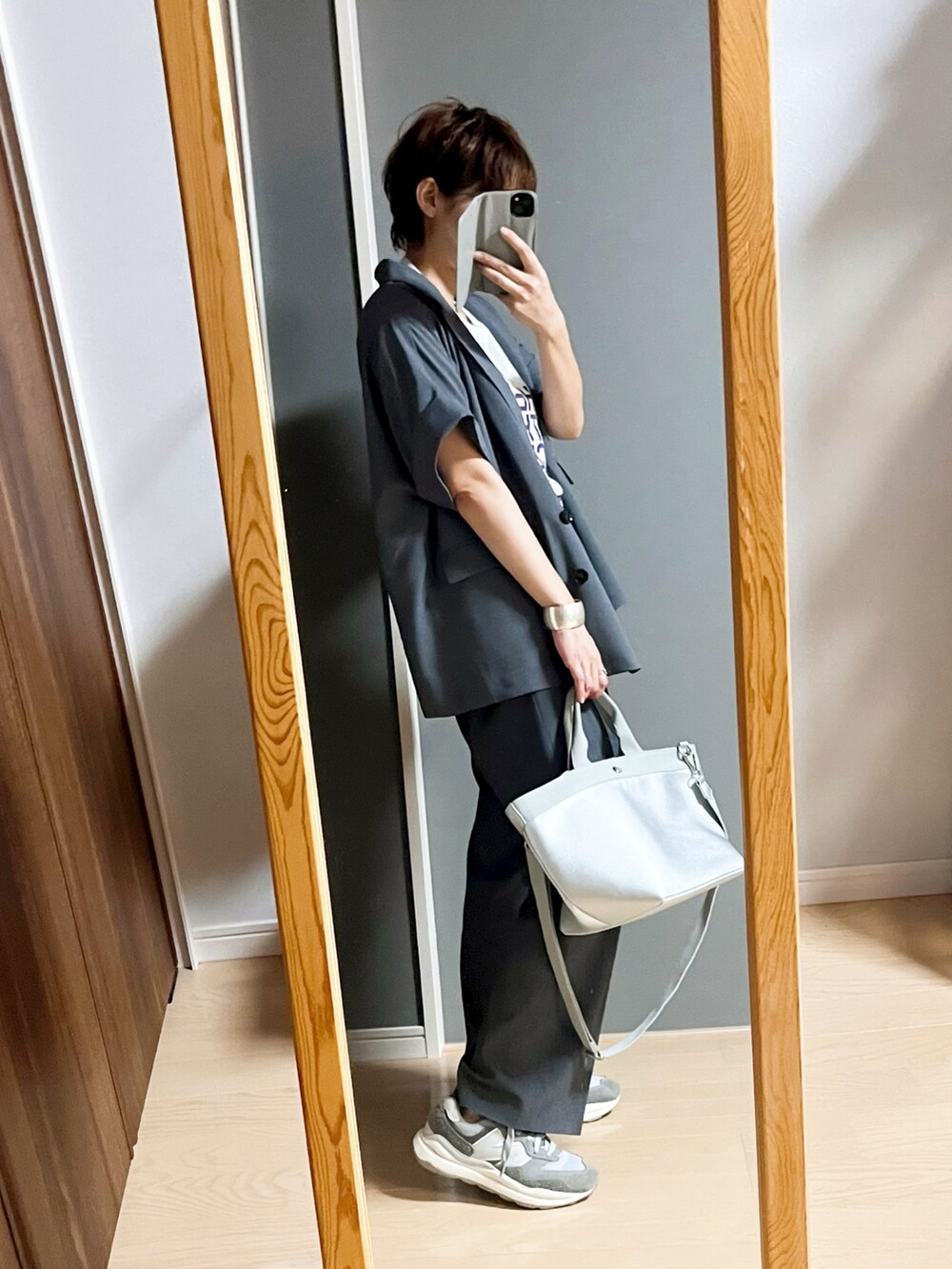 ホワイト系のTシャツ/カットソー、グレー系のシャツ/ブラウス、グレー系のパンツを着用したレディースの秋コーディネートの2枚目の写真