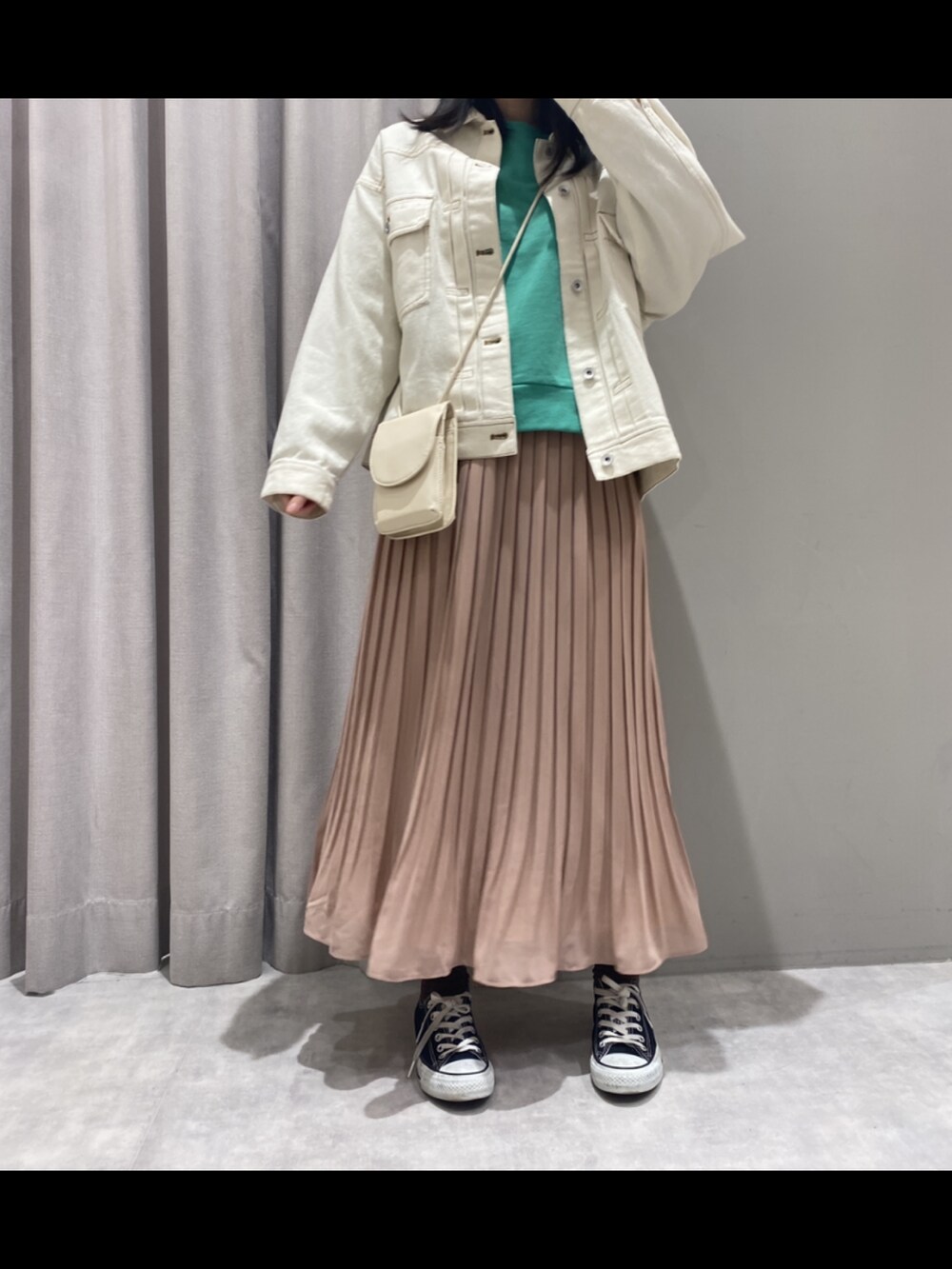 ピンク系のスカート、グリーン系のトップス、ベージュ系のジャケット/アウターを着用したレディースの冬コーディネートの2枚目の写真