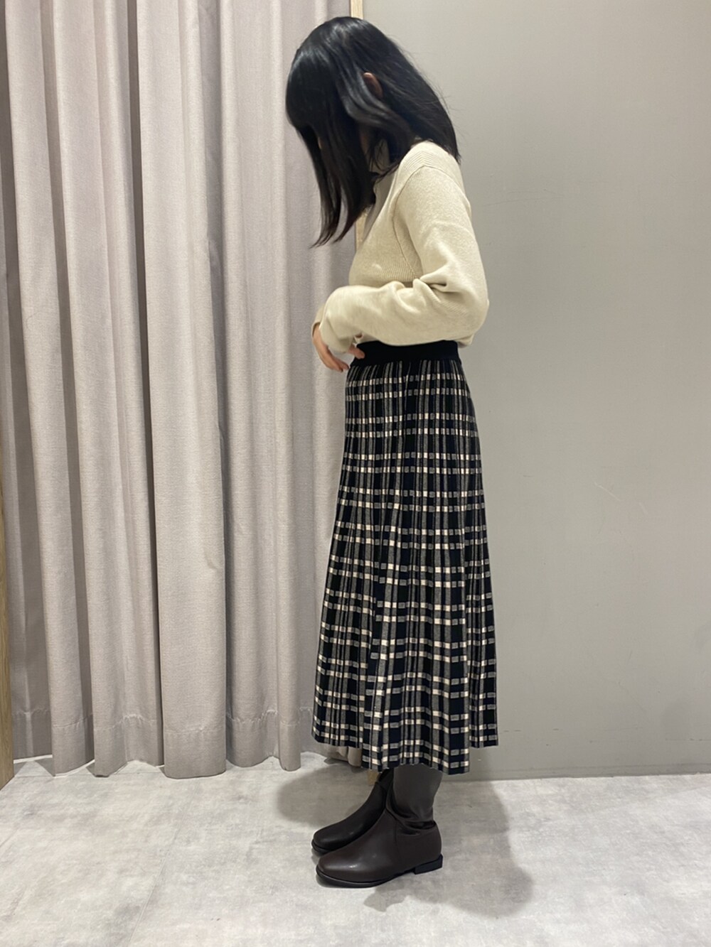 ベージュ系のトップス、ブラック系のスカート、ブラウン系のシューズを着用したレディースの冬コーディネートの3枚目の写真