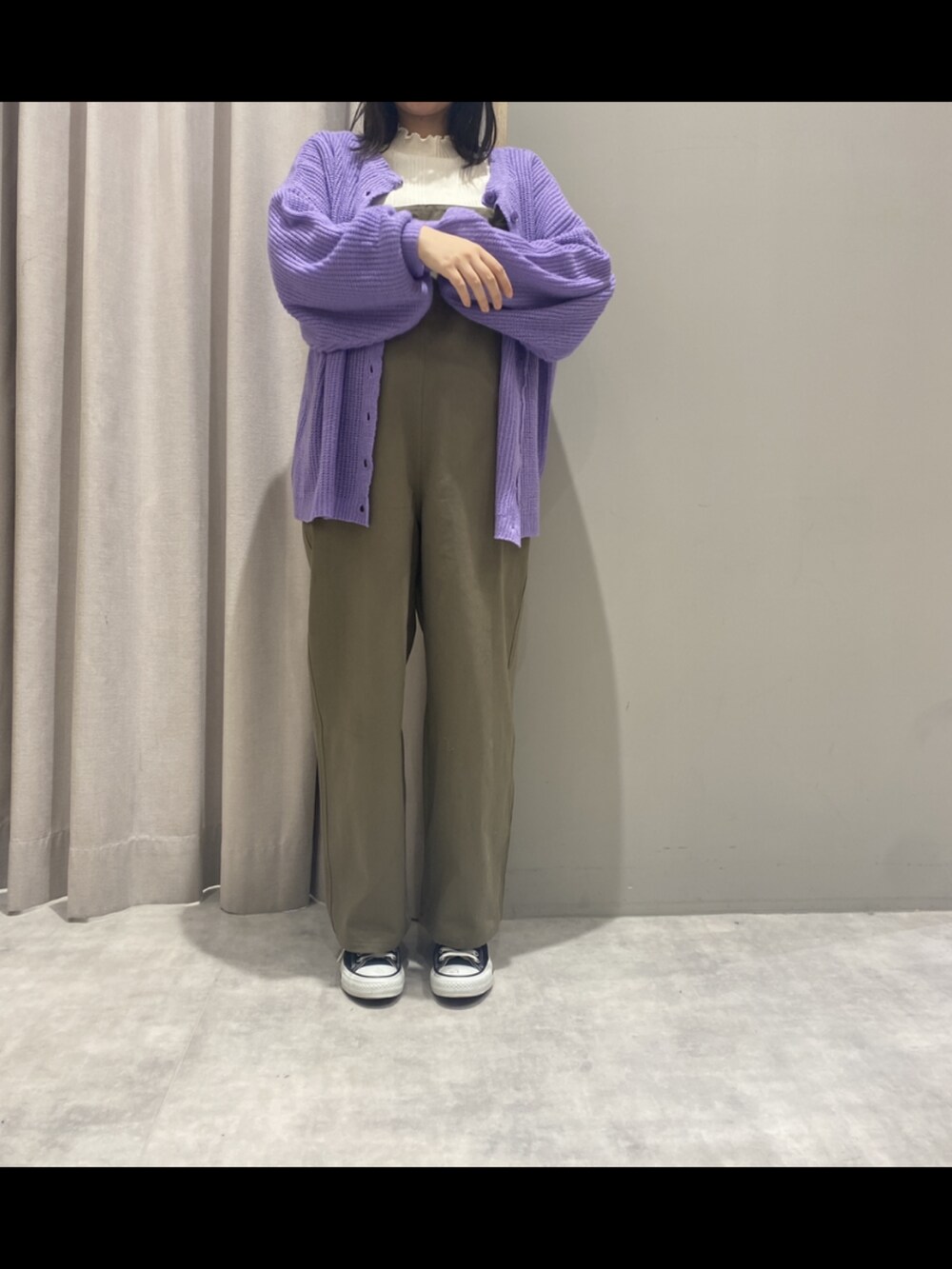 グレー系のスニーカー、グリーン系のオールインワン・サロペット、パープル系のカーディガン/ボレロを着用したレディースの冬コーディネートの2枚目の写真