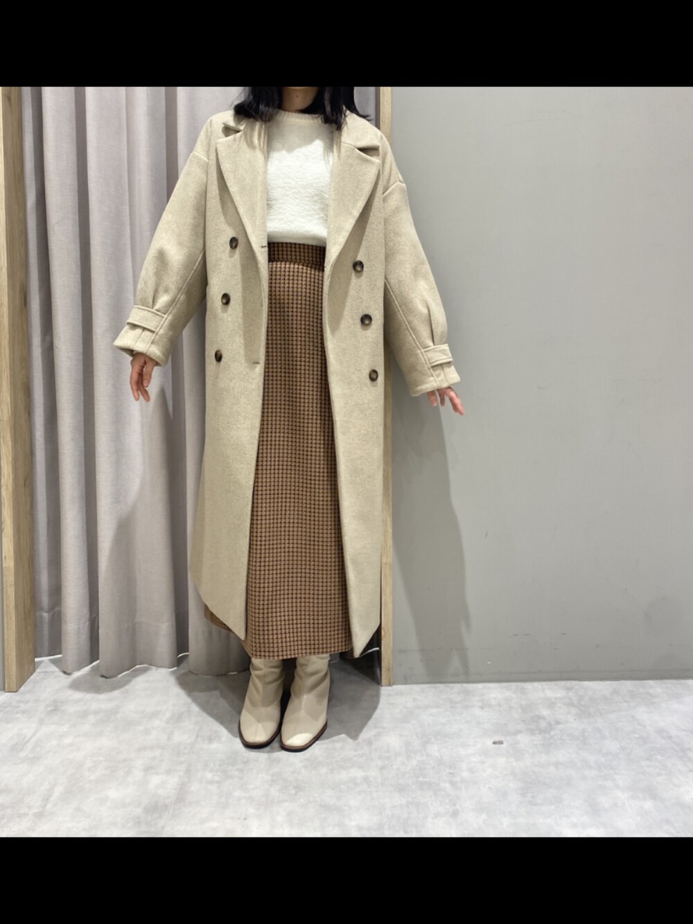 ブラウン系のスカート、ホワイト系のトップス、ベージュ系のジャケット/アウターを着用したレディースの冬コーディネートの2枚目の写真