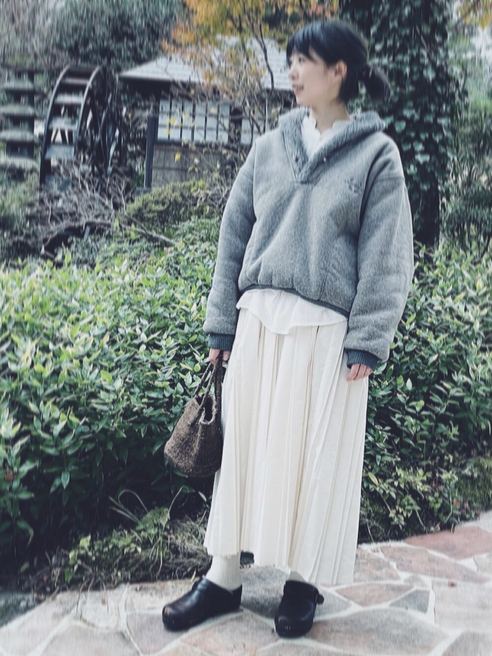 ブラウン系のバッグ、グレー系のニット/セーター、ホワイト系のワンピースを着用したレディースの冬コーディネートの3枚目の写真