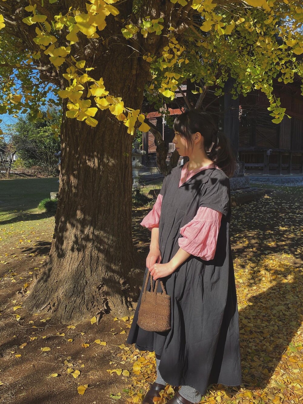 ブラウン系のバッグ、ブラウン系のその他シューズ、ピンク系のシャツ/ブラウスを着用したレディースの秋コーディネートの2枚目の写真