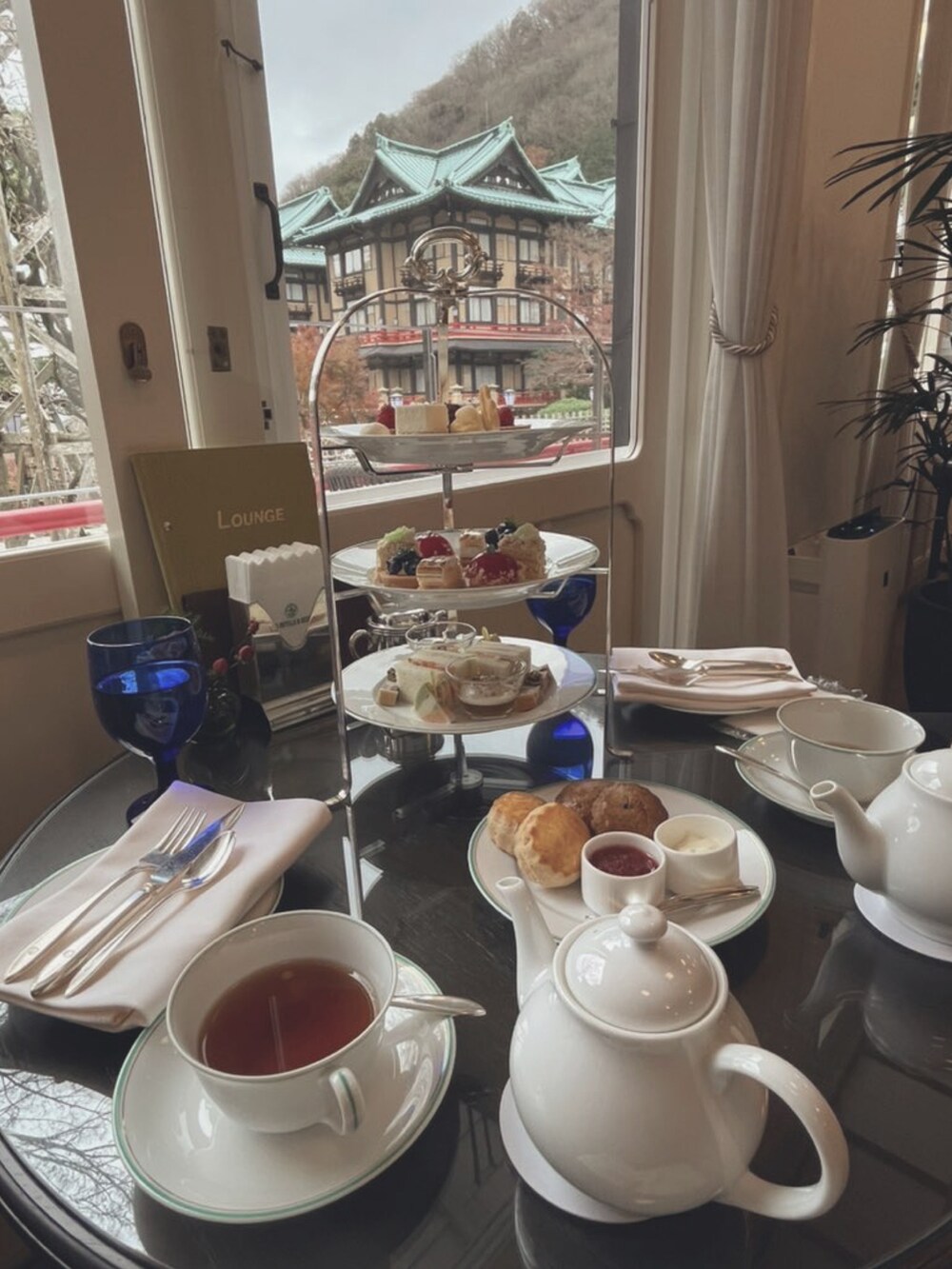 ブラウン系のバッグ、グレー系のニット/セーター、ホワイト系のワンピースを着用したレディースの冬コーディネートの4枚目の写真