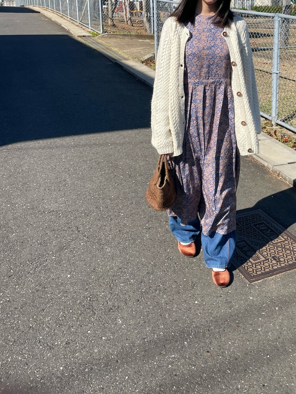 ブルー系のワンピース、ホワイト系のカーディガン/ボレロ、ブルー系のデニムパンツを着用したレディースの秋コーディネートの2枚目の写真
