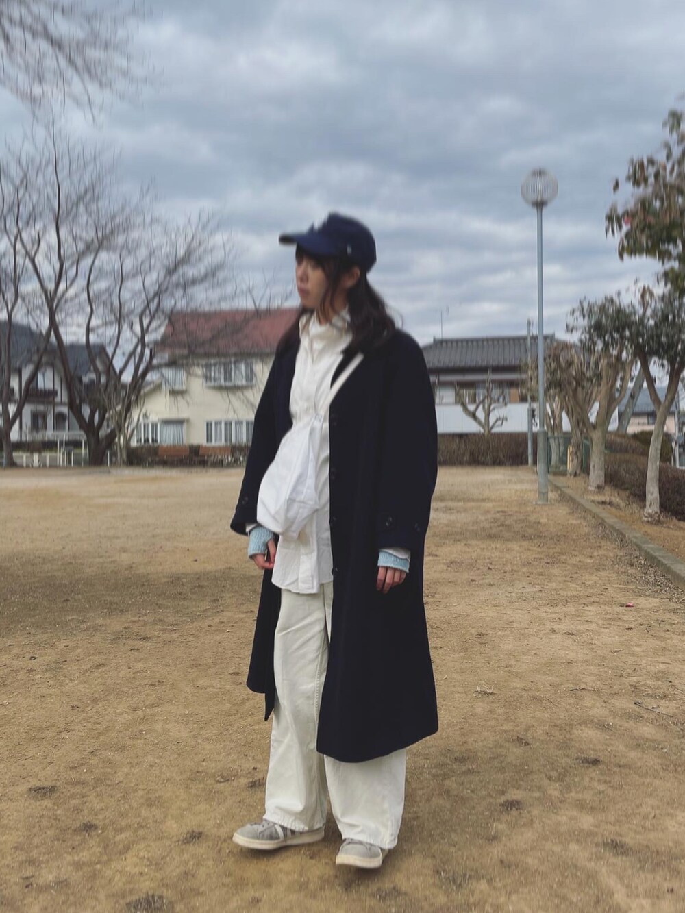 グレー系のスニーカー、ホワイト系のその他パンツ、ホワイト系のショルダーバッグを着用したレディースの冬コーディネートの2枚目の写真