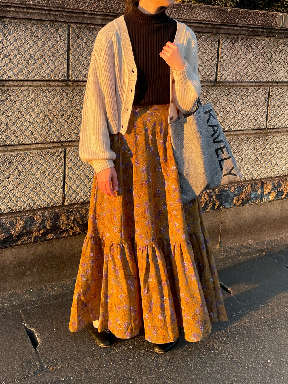 その他のトートバッグ、イエロー系のスカート、ブラック系のバレエシューズを着用したレディースの冬コーディネートの2枚目の写真