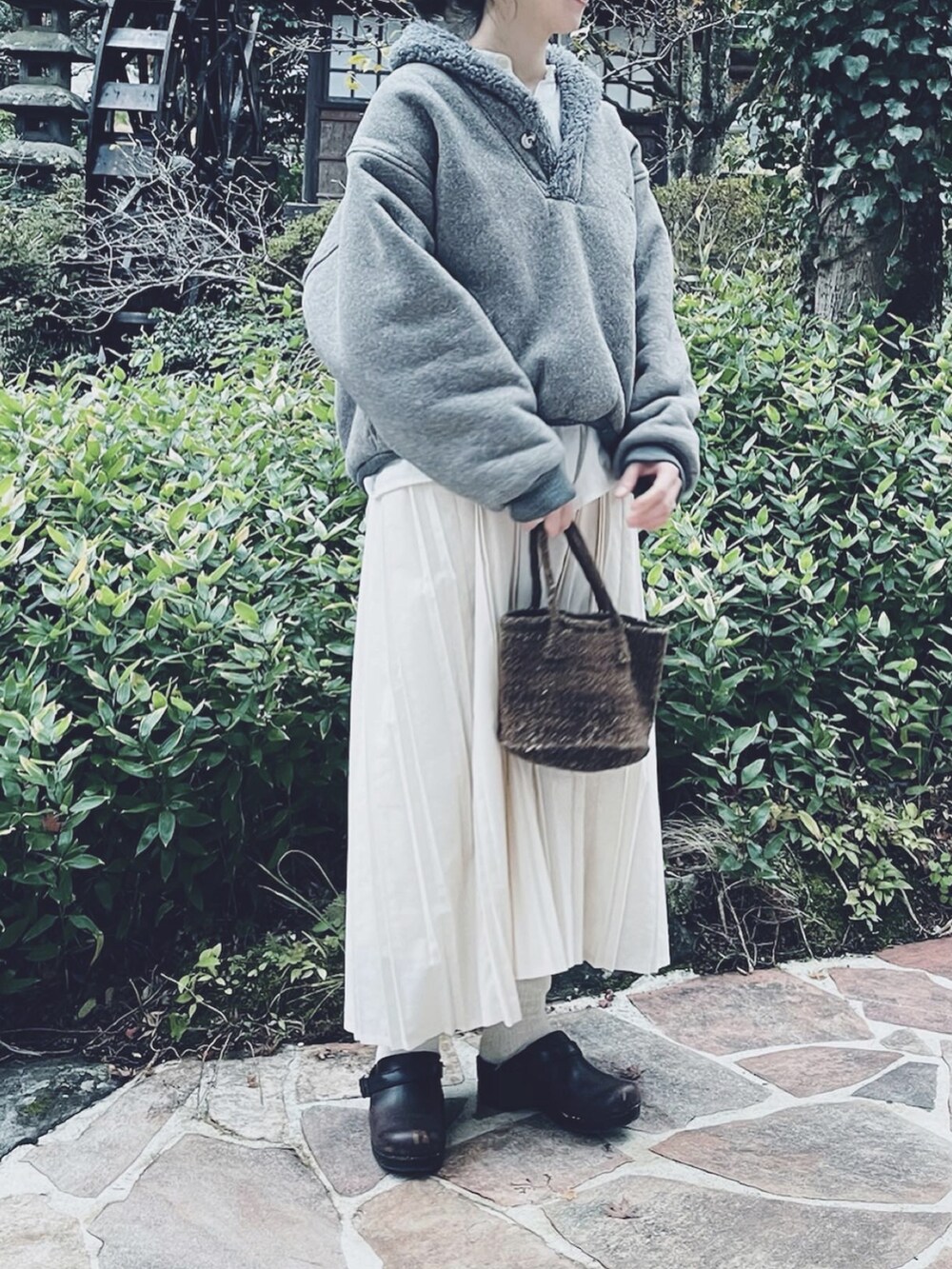 ブラウン系のバッグ、グレー系のニット/セーター、ホワイト系のワンピースを着用したレディースの冬コーディネートの2枚目の写真