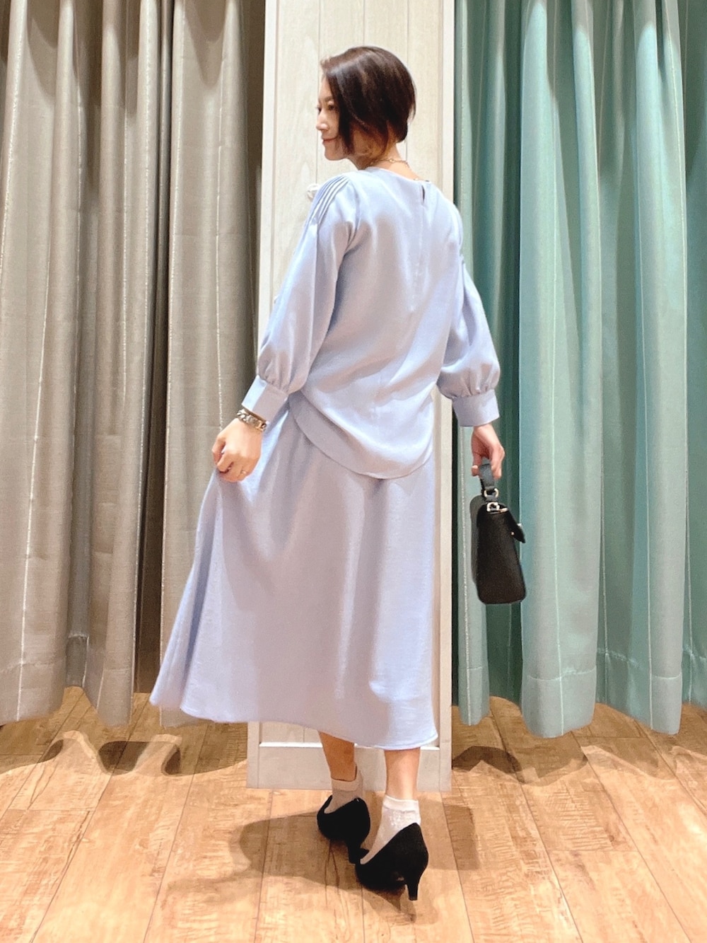 ブルー系のシャツ/ブラウス、ブルー系のスカート、ブラック系のパンプスを着用したレディースの春コーディネートの3枚目の写真