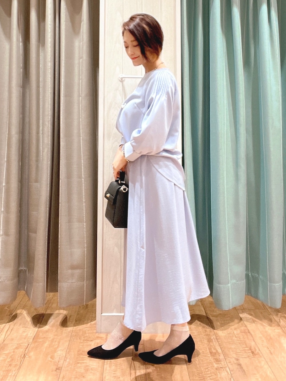 ブルー系のシャツ/ブラウス、ブルー系のスカート、ブラック系のパンプスを着用したレディースの春コーディネートの2枚目の写真