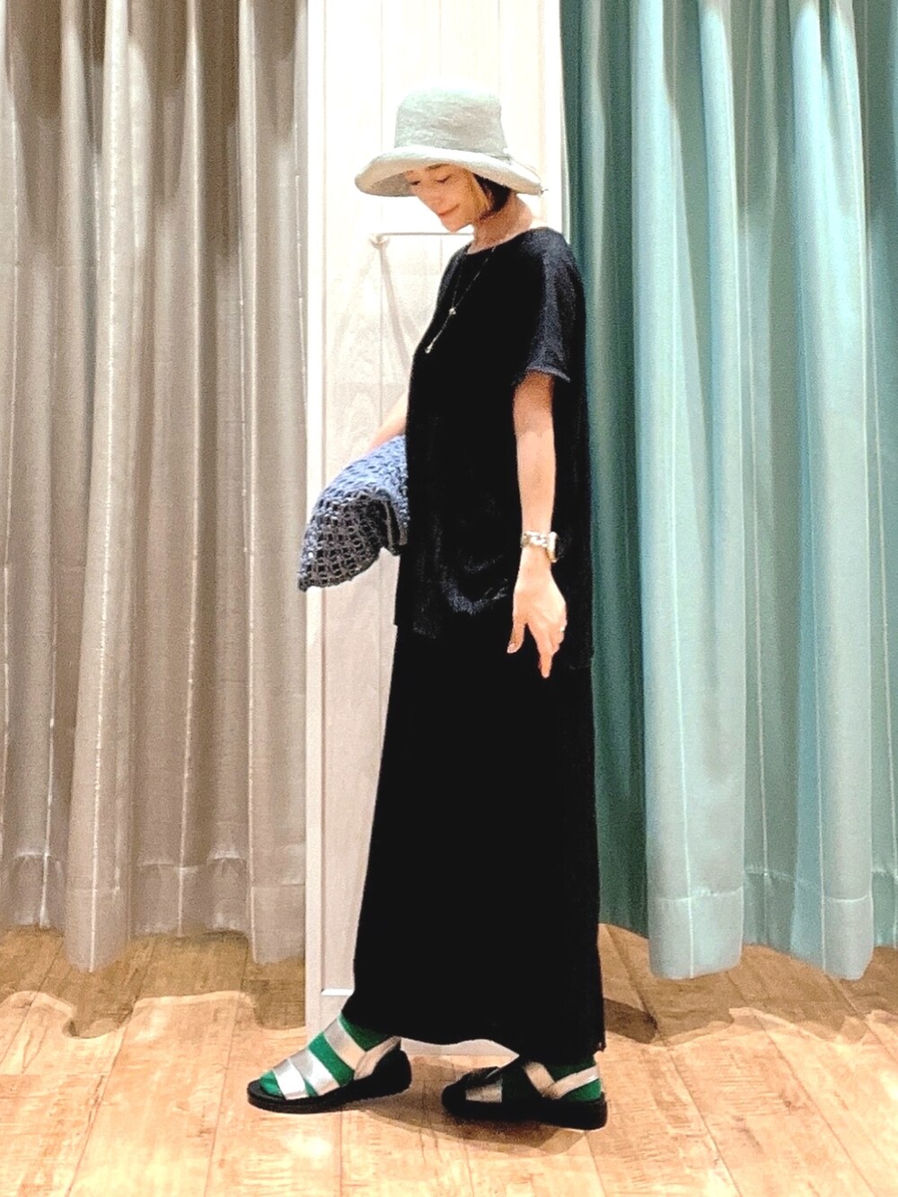 ブラック系のシャツ/ブラウス、ブラック系のスカート、ブルー系のトートバッグを着用したレディースの夏コーディネートの2枚目の写真