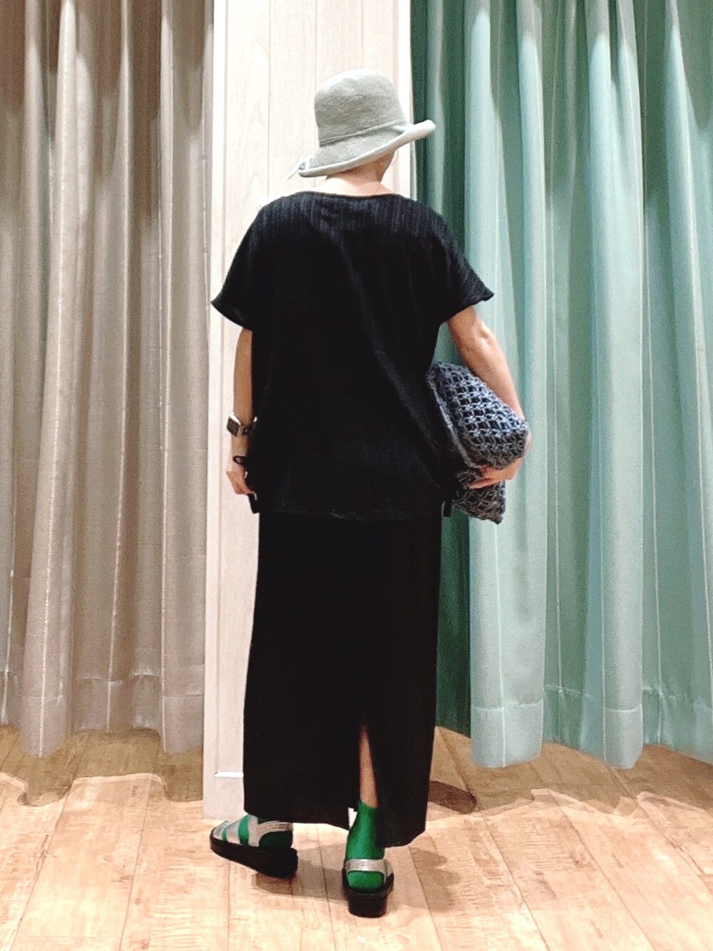 ブラック系のシャツ/ブラウス、ブラック系のスカート、ブルー系のトートバッグを着用したレディースの夏コーディネートの3枚目の写真