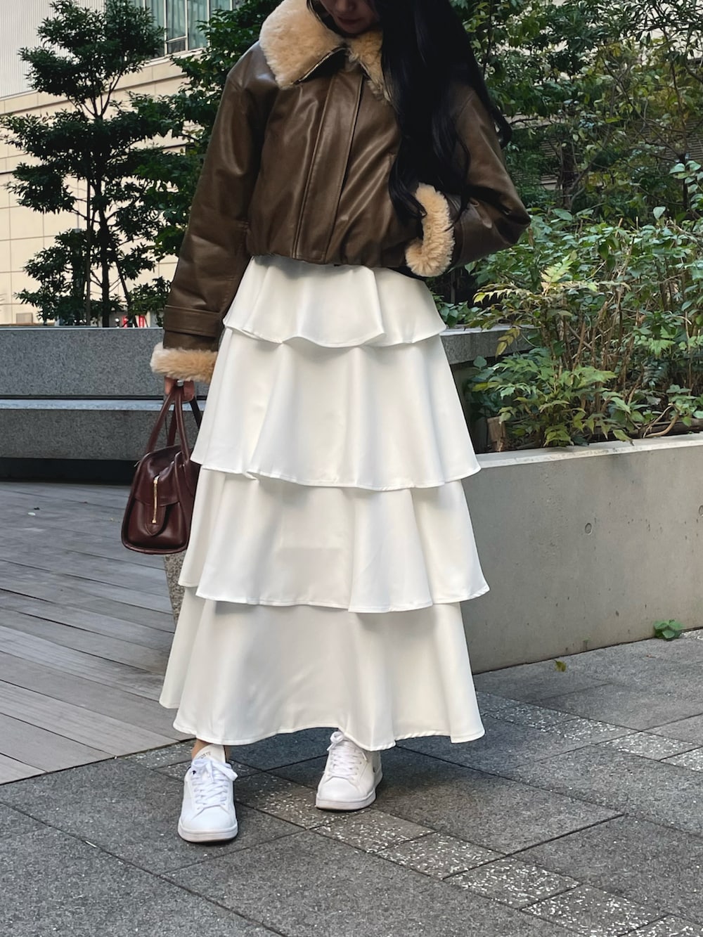 ブラウン系のその他アウター、ホワイト系のスカート、ホワイト系のスニーカーを着用したレディースの秋コーディネートの3枚目の写真