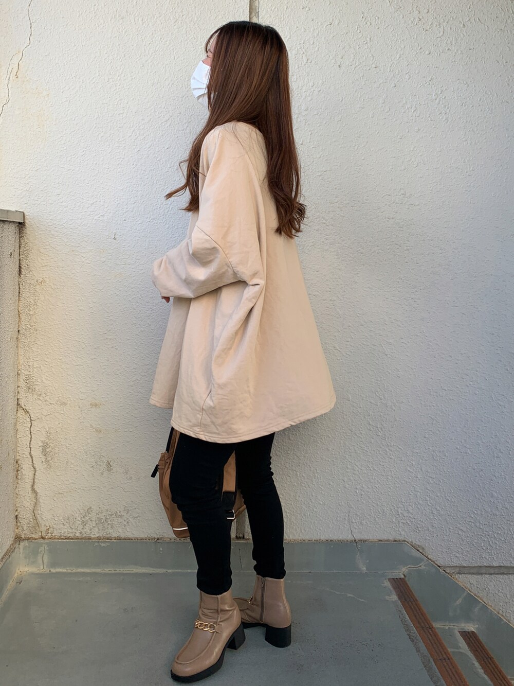 ブラック系のノーカラージャケット、ブラック系のデニムパンツ、ベージュ系のブーツを着用したレディースの秋コーディネートの3枚目の写真