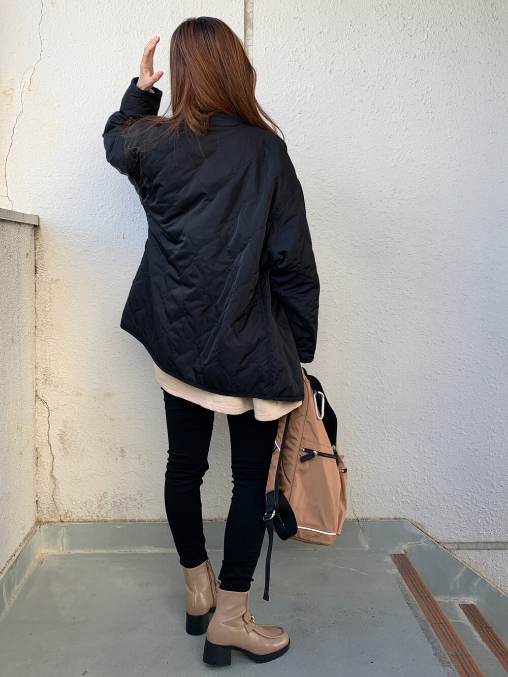 ブラック系のノーカラージャケット、ブラック系のデニムパンツ、ベージュ系のブーツを着用したレディースの秋コーディネートの2枚目の写真