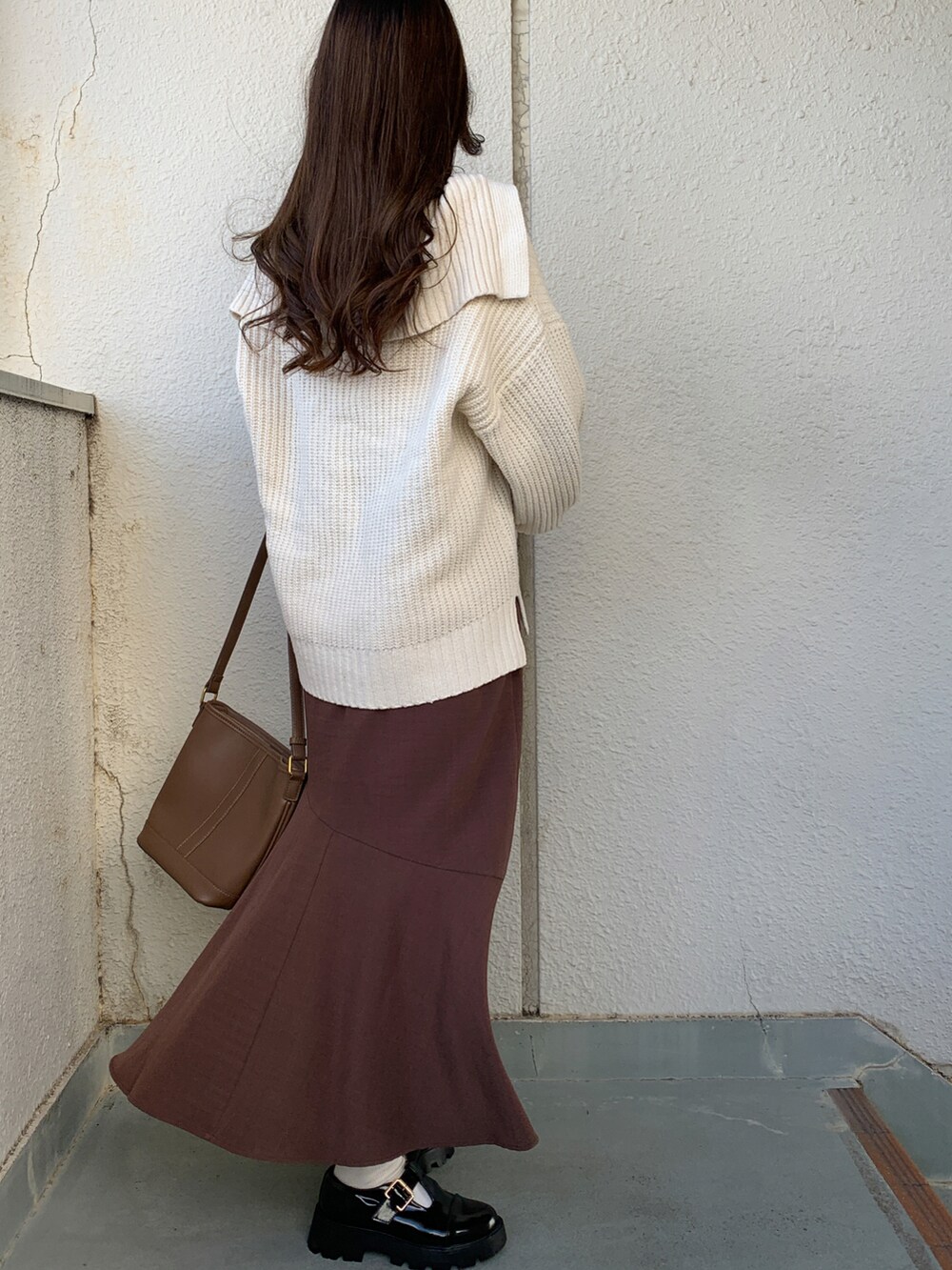 ホワイト系のニット/セーター、ブラック系のドレスシューズを着用したレディースの冬コーディネートの2枚目の写真